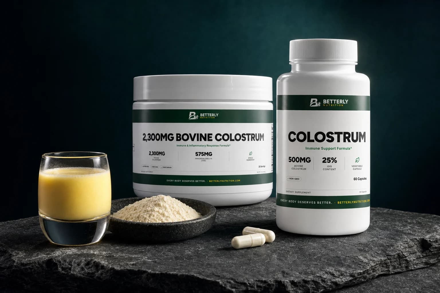 Colostrum capsule bottle and 2,300mg Bovine Colostrum tub on dark stone by a glass of golden colostrum, a dish of powder and two capsules