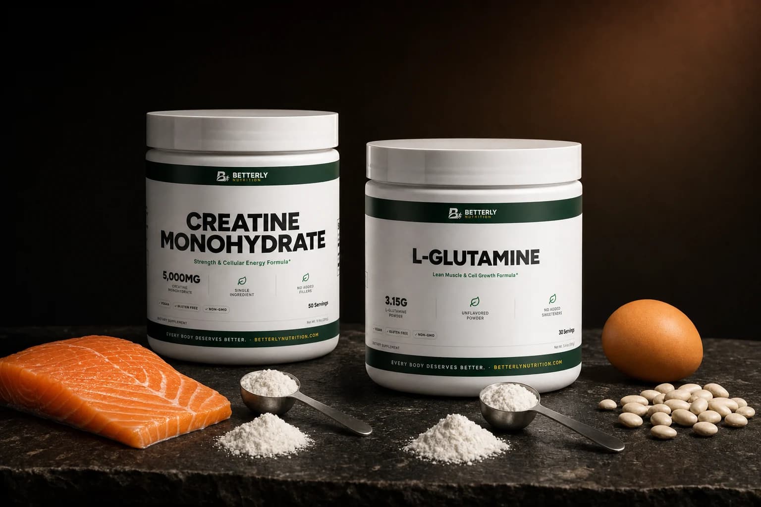 Creatine Monohydrate Powder and L-Glutamine Powder tubs on dark stone beside two scoops of white powder, a salmon fillet, beans and an egg