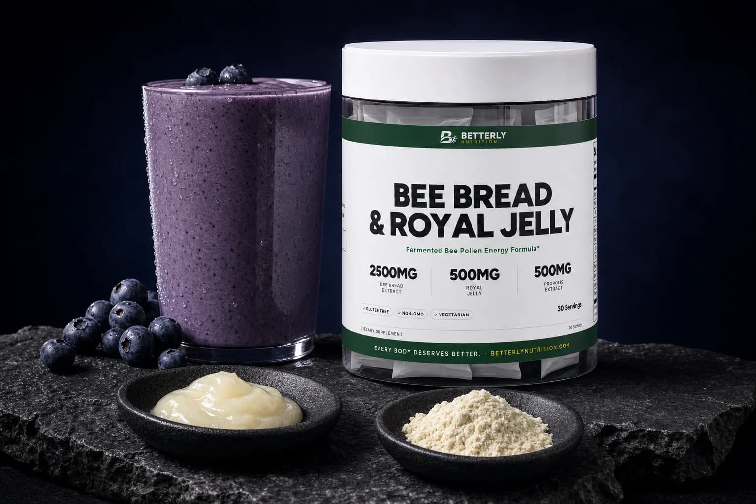 Bee Bread & Royal Jelly tub on dark stone beside a blueberry smoothie, with dishes of fresh royal jelly and pale powder in front