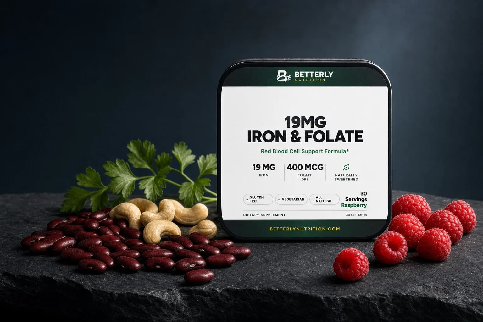 Betterly 19mg Iron & Folate Strips tin on dark stone, kidney beans, cashews and parsley to its left, raspberries to its right, navy backdrop