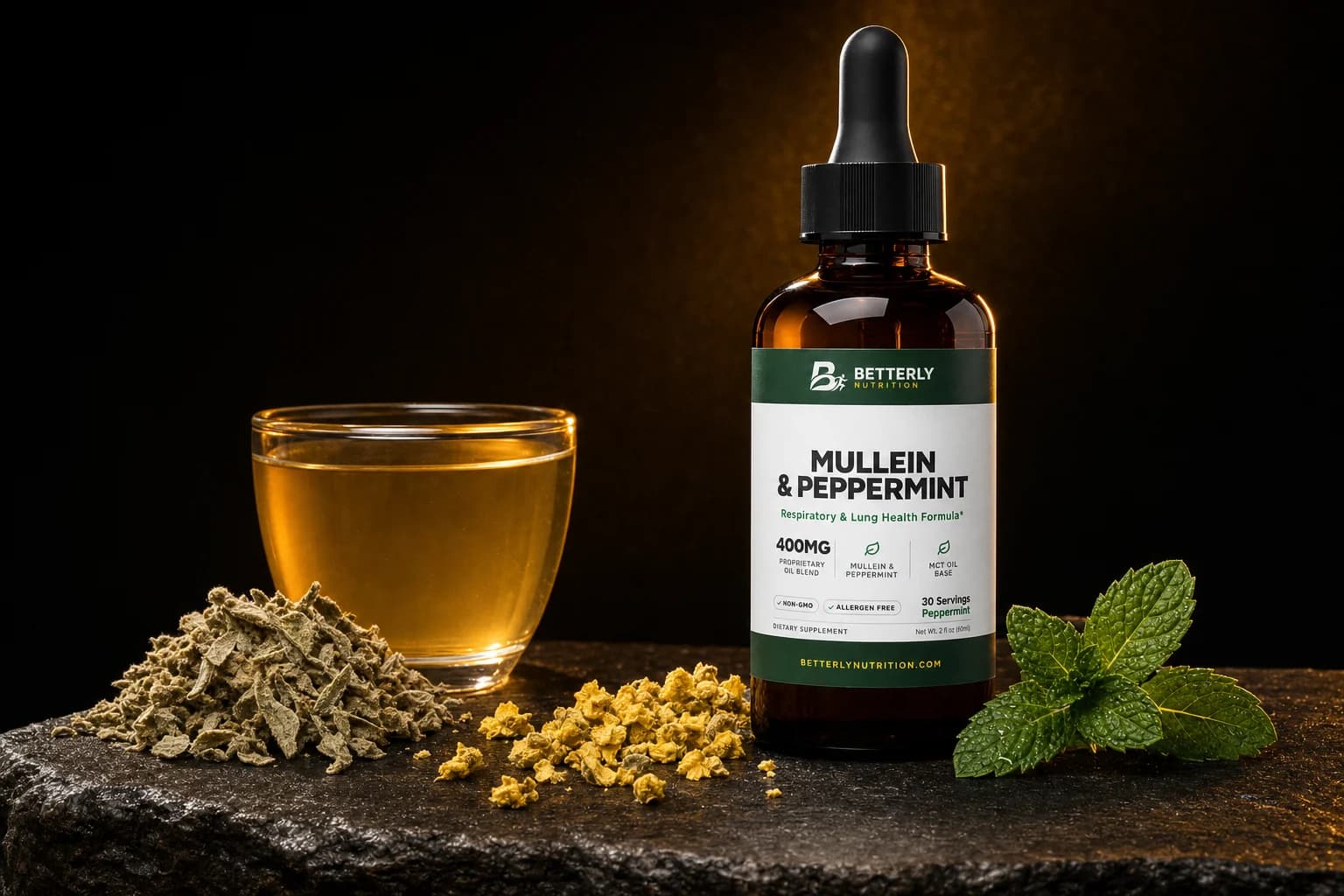 Mullein & Peppermint amber dropper bottle on dark rock beside a glass of golden tea, a heap of dried mullein leaves, yellow flowers and mint