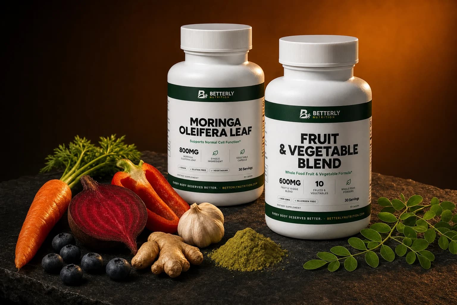Moringa Oleifera Leaf and Fruit & Vegetable Blend bottles on dark slate with carrot, beet, blueberries, pepper, ginger and green powder