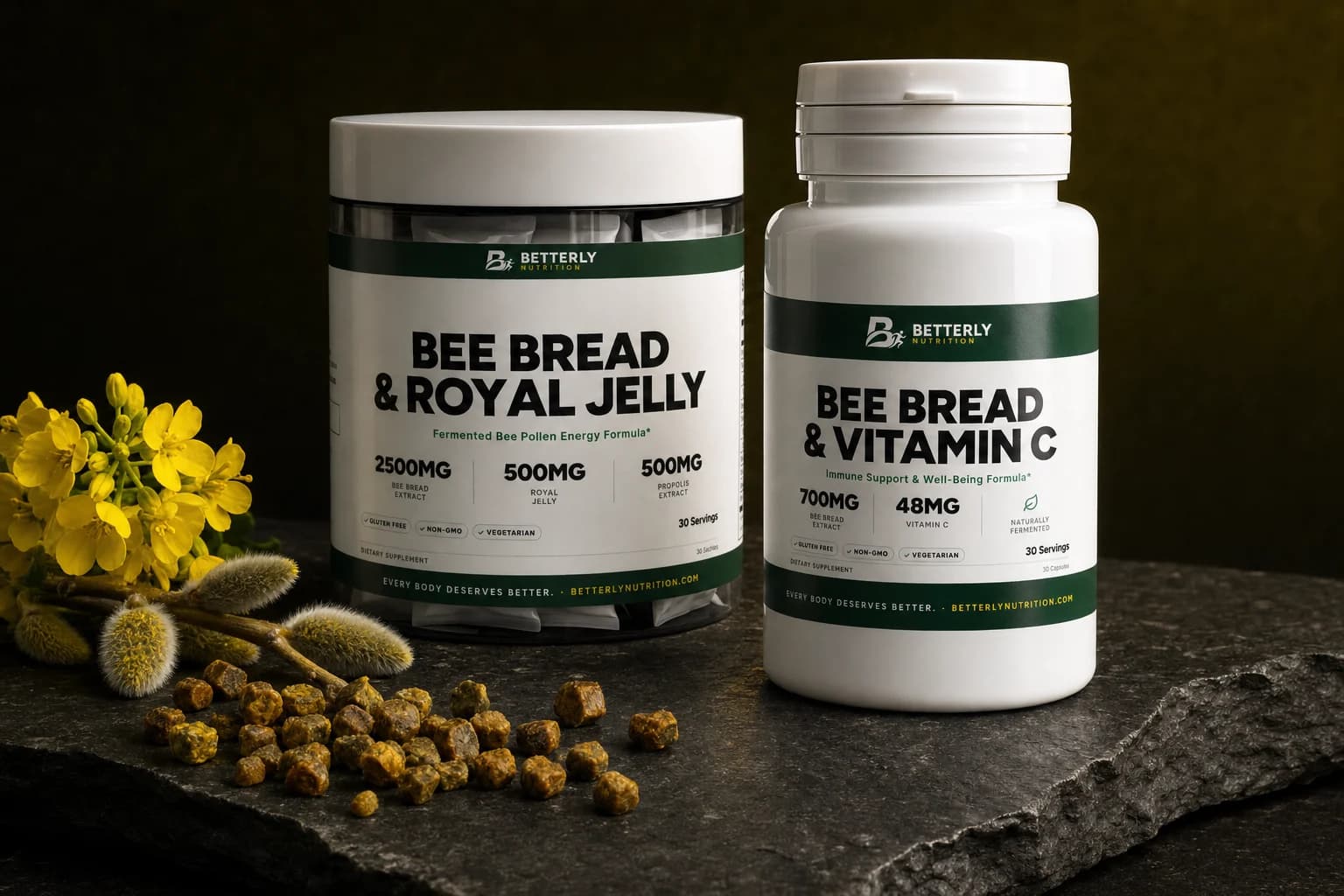 Bee Bread & Royal Jelly tub and Bee Bread & Vitamin C bottle on dark slate beside bee bread granules, willow catkins and rapeseed flowers