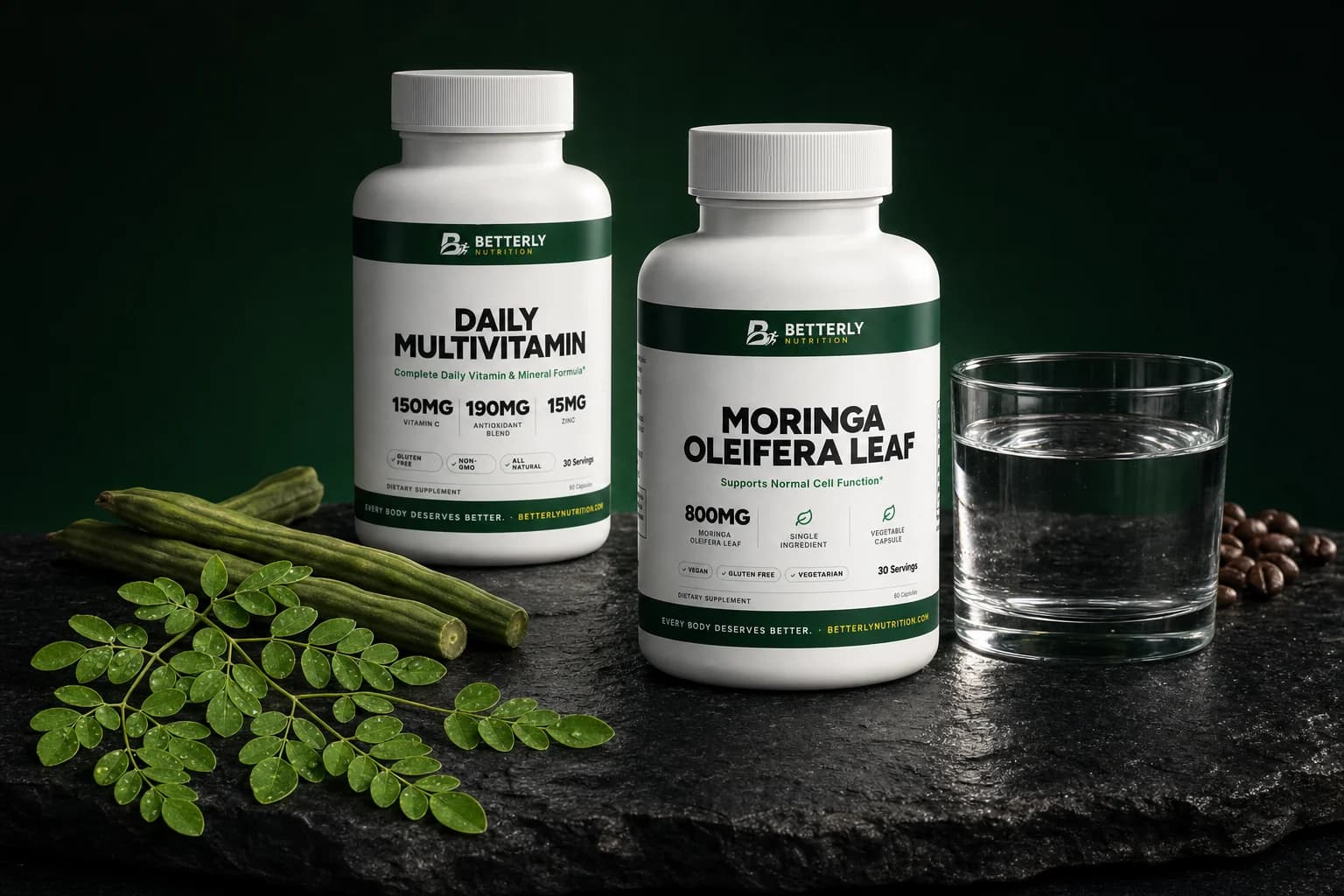 Moringa Oleifera Leaf and Daily Multivitamin bottles on dark slate with moringa sprigs, drumstick pods, a glass of water and coffee beans