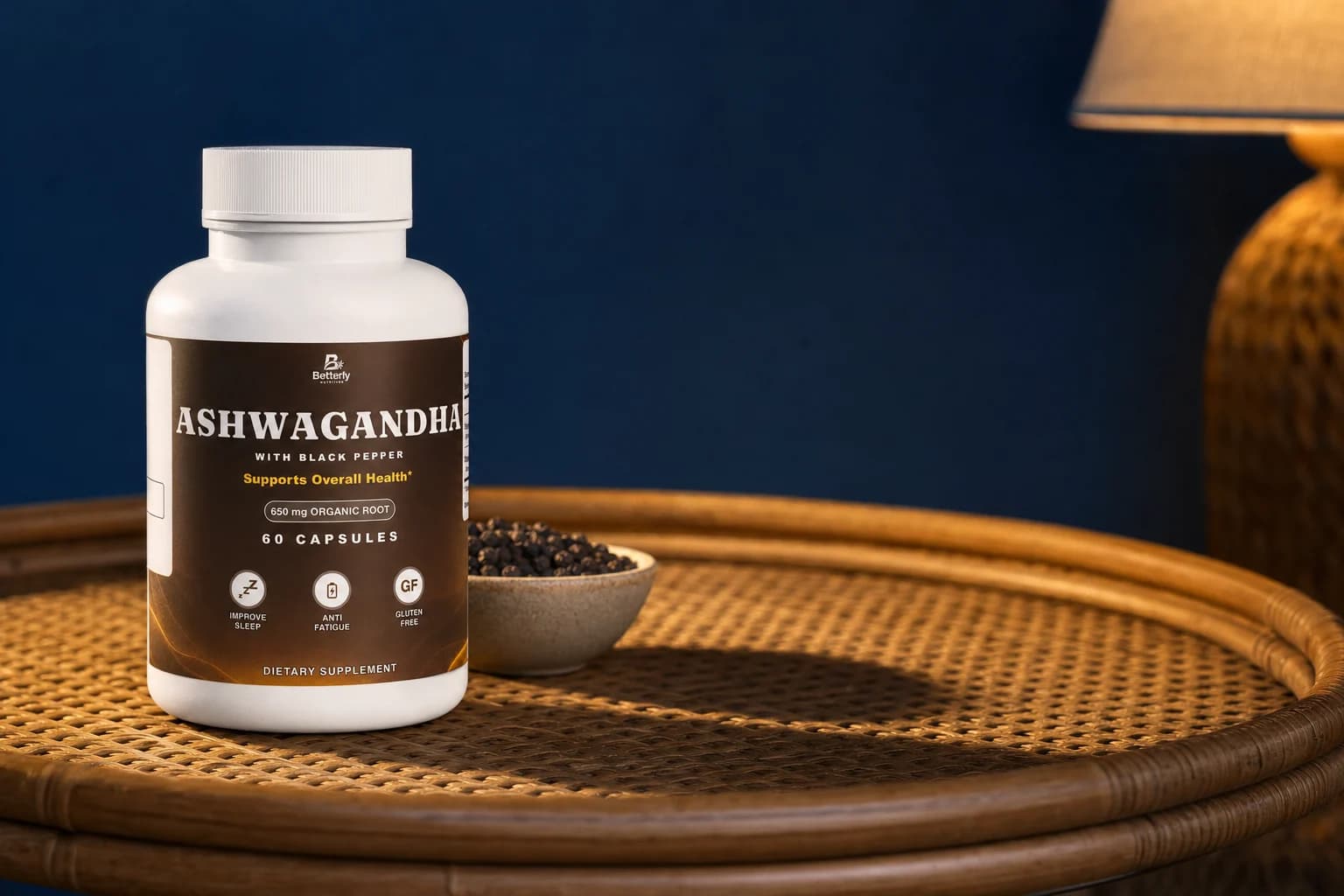 Ashwagandha bottle on a woven cane tray at dusk beside a small peppercorn bowl