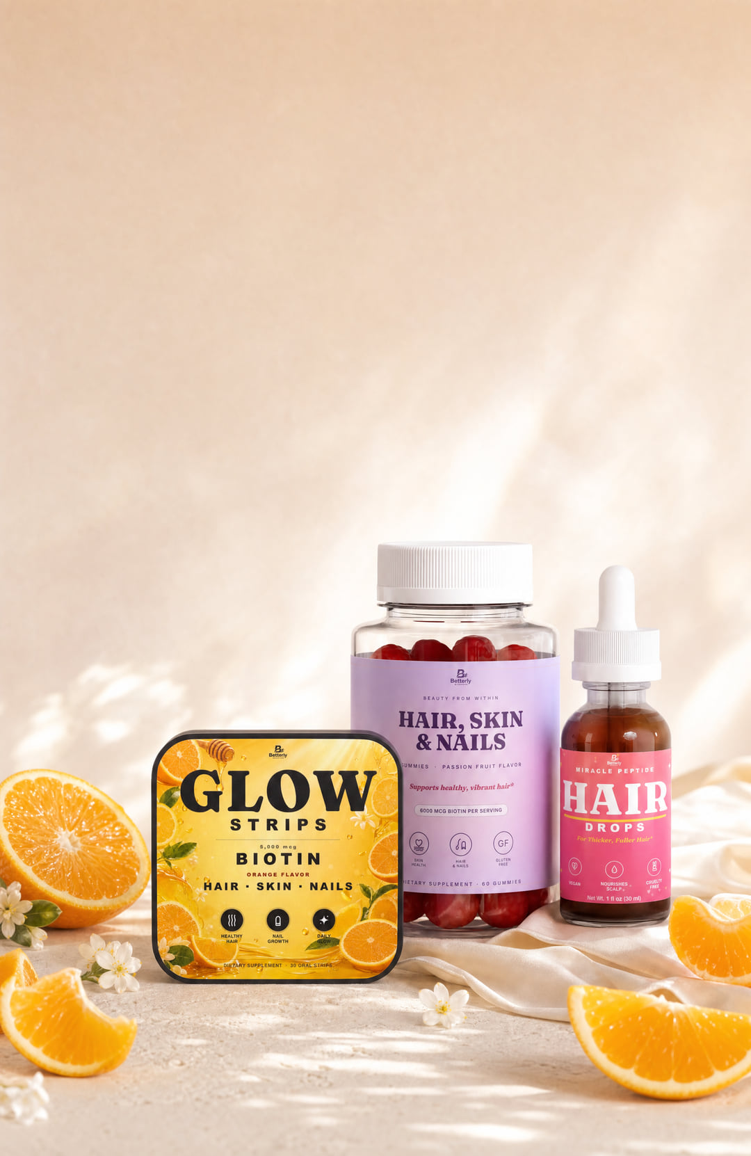 Betterly Hair Skin and Nails gummies, GLOW biotin strips and peptide hair serum on rose-gold silk